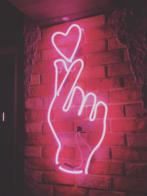 neon hand with fingers in heart position with a heart above it.